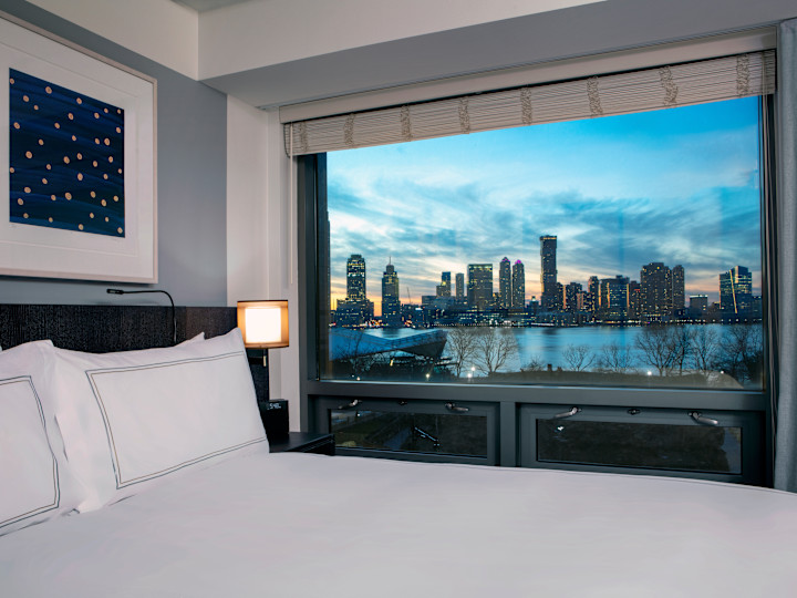 Bed in room with view of Hudson River outside