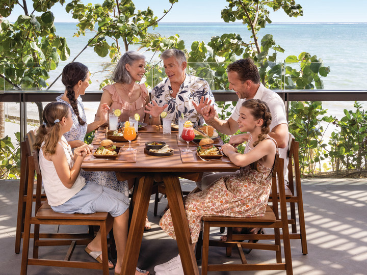 Mixed generational family shares a meal by the ocean