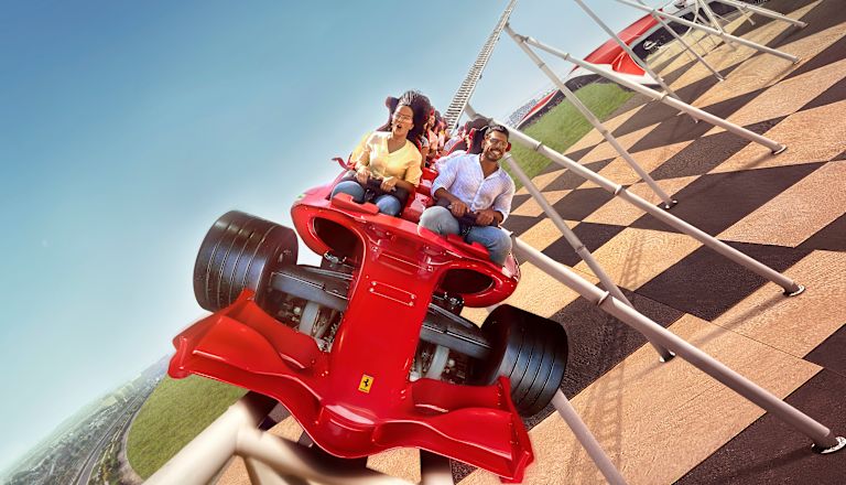 eine Gruppe von Personen, die in der Ferrari World eine Achterbahn fahren