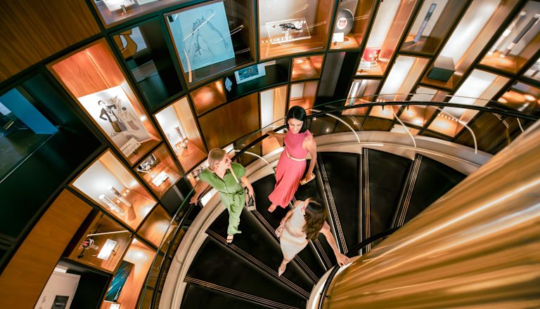 Drei Frauen gehen die Wendeltreppe hinunter