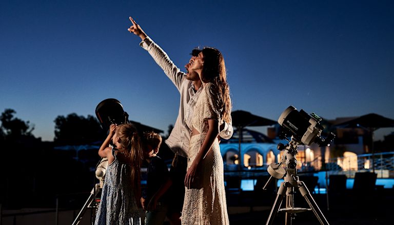 Family Looking at the Stars with a Telescope at Night