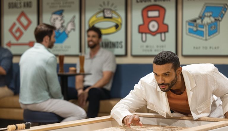 Man som spelar shuffleboard på Dive Bar
