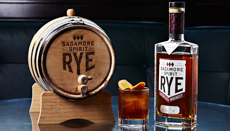 Sagamore Spirit Rye Whiskey في برميل صغير بجوار كأس