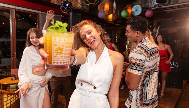 Trader Vic's JBR image, with woman raising glass towards camera