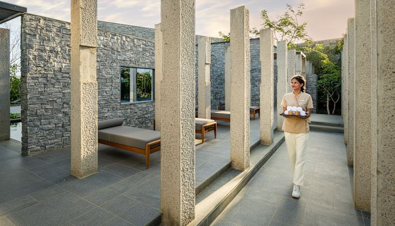 Staff member walking through outdoor spa area