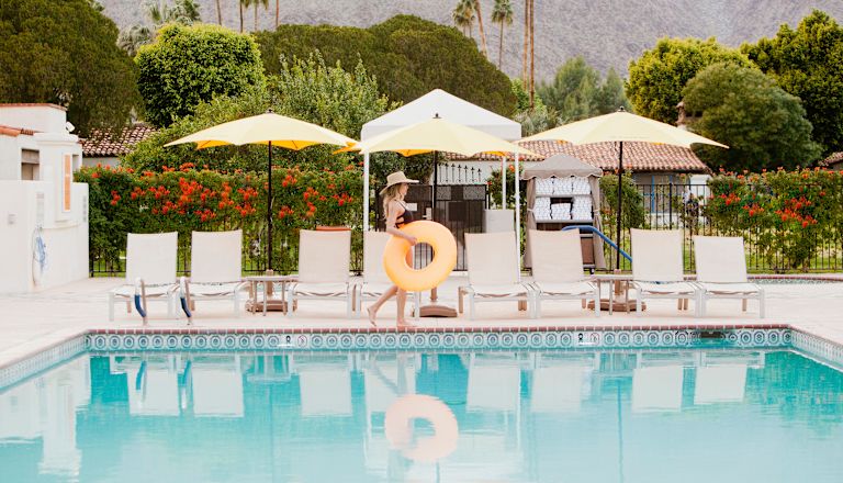 Woman walking past pool with rubber ring