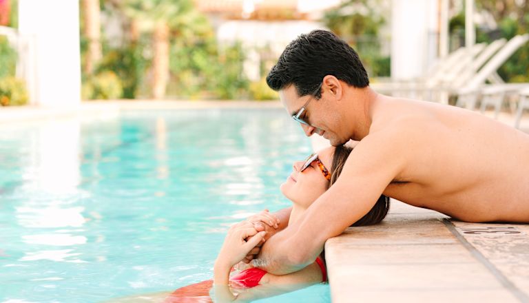 Man and woman relaxing by pool