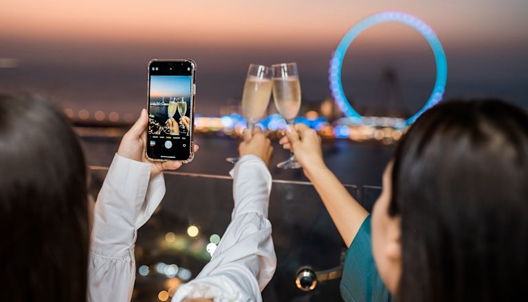 Two girls taking a photography on their phone of the Dubai Eye