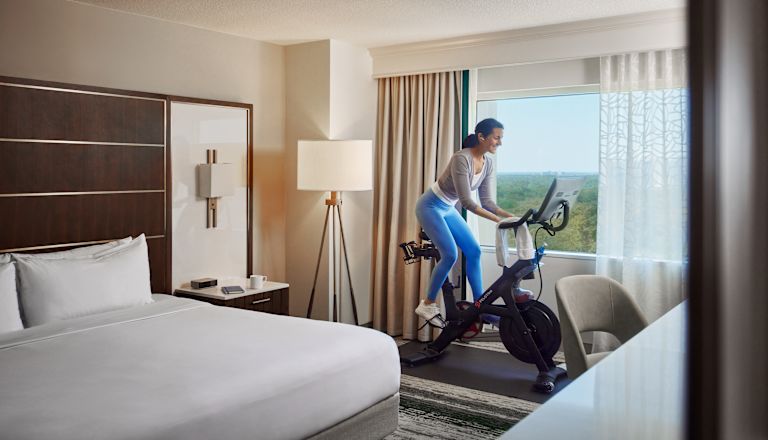 Mujer haciendo ejercicio en una bicicleta fija en su habitación