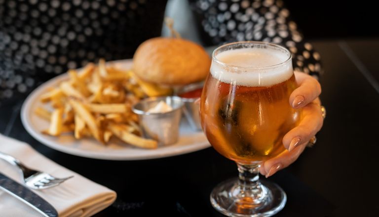uma mulher almoçando e um urso no restaurante Brass Tack