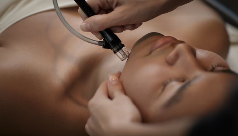 Mulher recebendo uma massagem facial no spa
