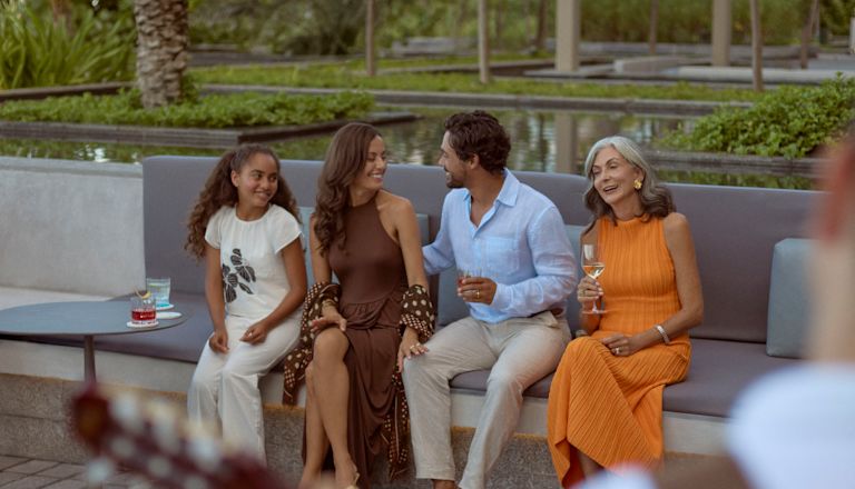 Family consisting of daughter, mother, father and grandmother enjoying live music next to the firepit