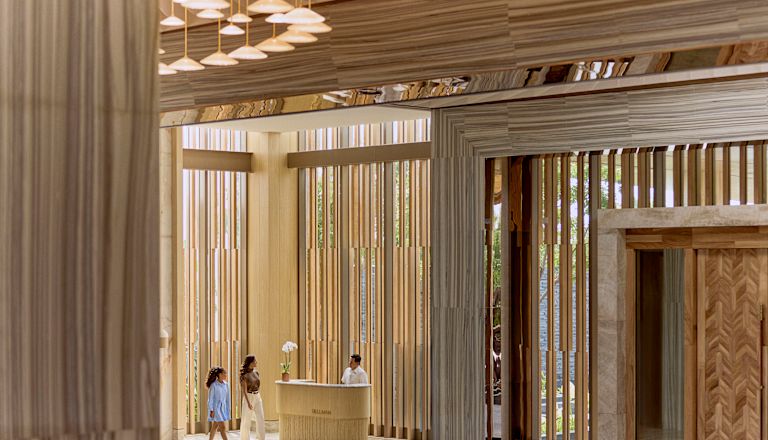 mother and daughter walking past hotel reception desk