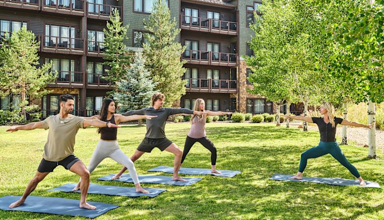 A Group of People Practicing Yoga Outdoors