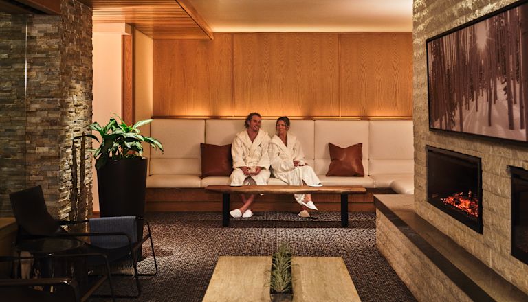Couple Relaxing in Seating Area by the Fireplace at the Spa