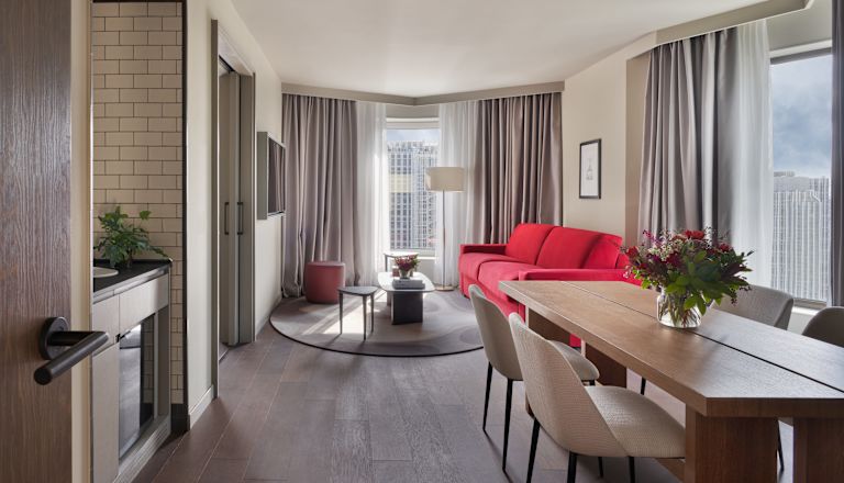 Suite de un dormitorio con cama King y vista a la ciudad