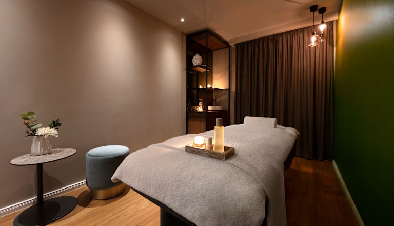 Massagebett mit Spa-Produkten auf einem Tablett