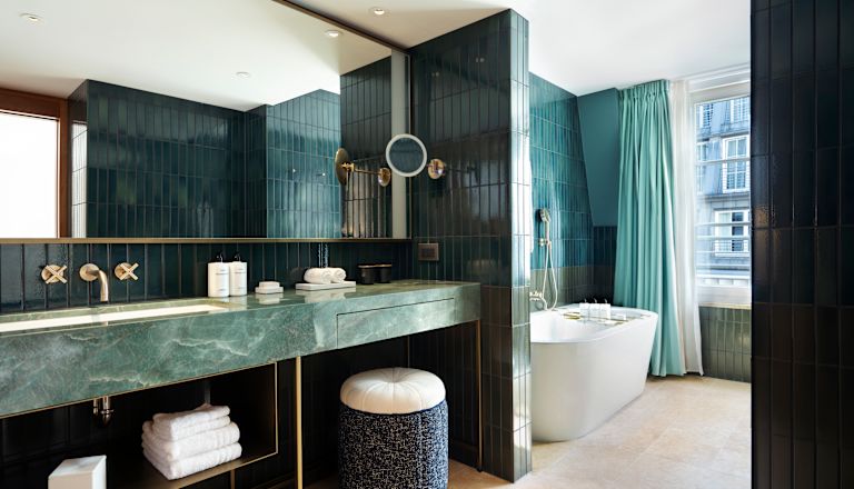 Badezimmer des Zimmers – Toilettentisch, Handtücher, Spiegel, Badewanne