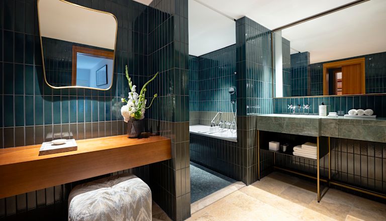 Badezimmer des Zimmers mit Toilettentisch, Spiegel, Badewanne