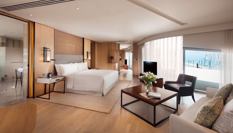 suite with bed, living area, and terrace