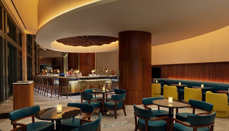 Barul și zona de lounge din hotelul Apero cu scaune pentru masă și banchetă.