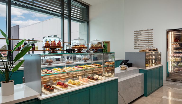 Micul lingou în magazinul de deserturi al hotelului, cu gustări colorate decorate în răcitoare și tăvi acoperite.