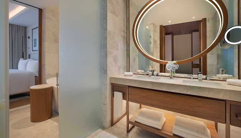 Dubbelt toalettbordsområde med rund spegel i en hotellsvit