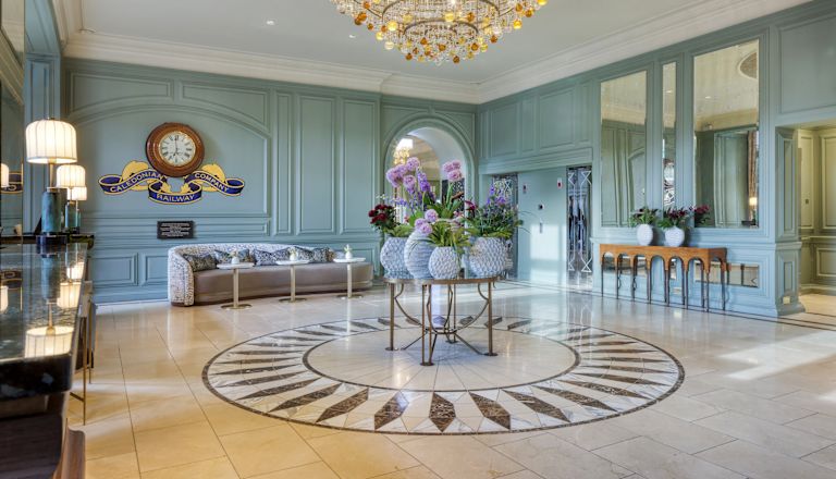 Zonă de lobby cu scaune confortabile, flori și un candelabru mare