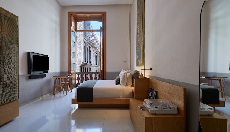 Camera - Letto, panca e doppie porte apribili sul balcone.