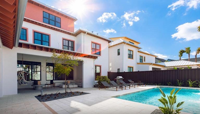 Exteriorul clădirii cu șezlonguri, piscină și copaci