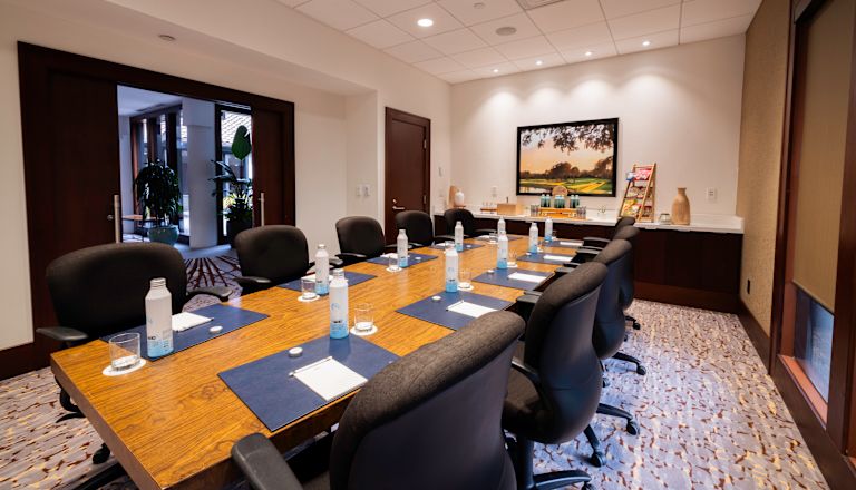 Sala de conferințe cu scaune orientate spre ecranul proiectorului
