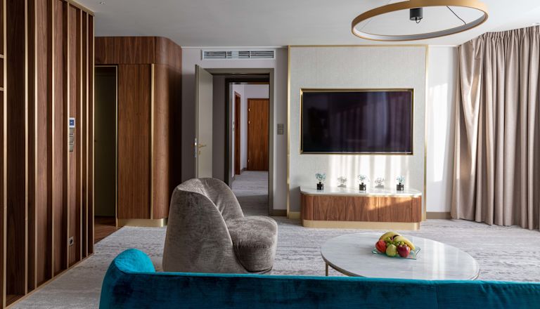 Suite Royal - Zona soggiorno con divano, poltrona e TV