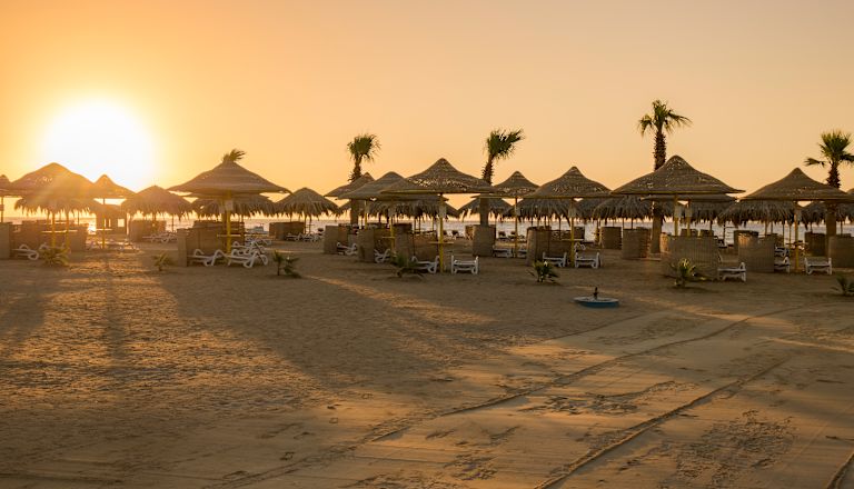 Sunrise at Beach Area with Straw Umbrellas