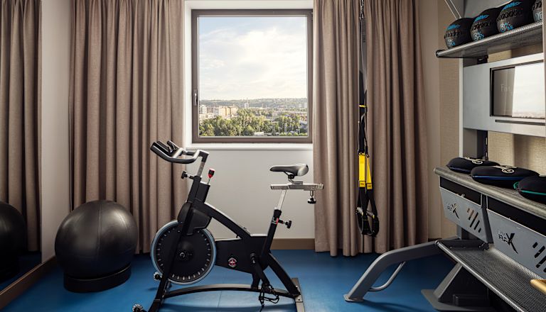 Trainieren Sie mit dem Fahrrad, Gewichten und anderen Trainingsgeräten in einem Zimmer