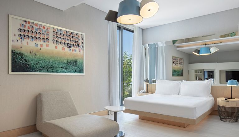 Bed in kamer met ligstoel en tafel