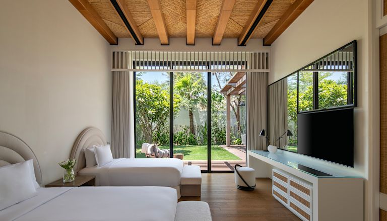 Due letti e TV in una villa con vista sul giardino