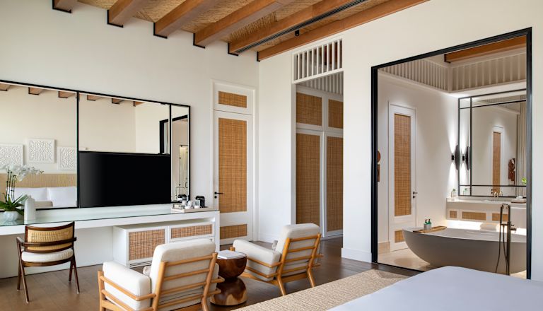 Panoramica di una suite con ampio letto, salotto e vasca da bagno