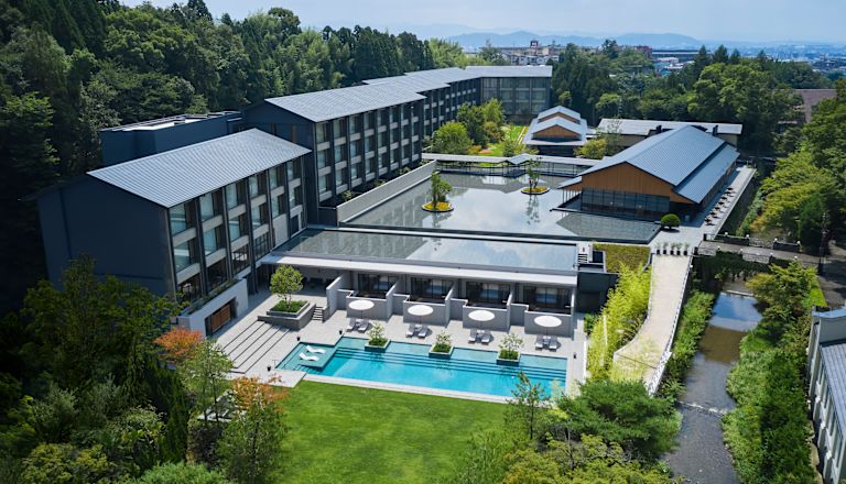 Fasada hotelu z basenem i drzewami