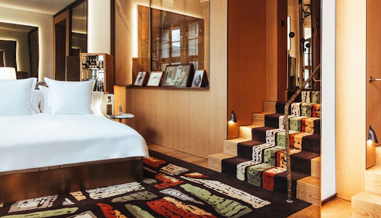 King size bed and stairs leading to second level of suite