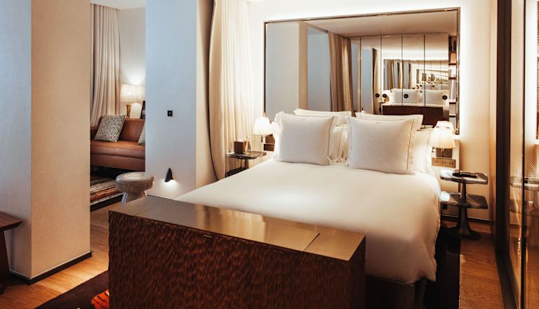 King size bed with view to lounge area with sofa in background
