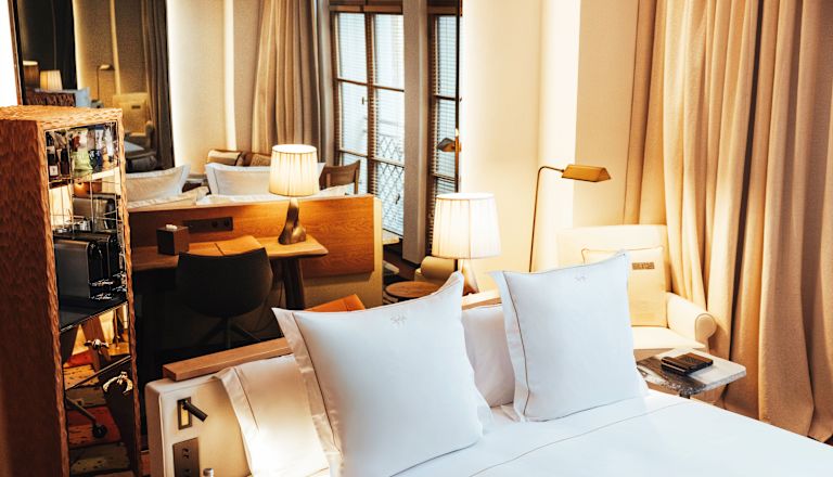 Bed in room with two pillows, lighting and side table
