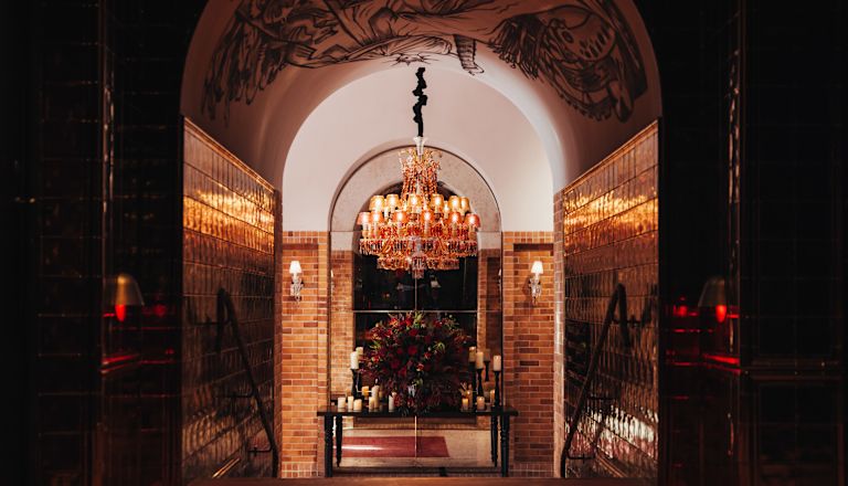 Entrance to hotel reception with flower arrangement and chandelier