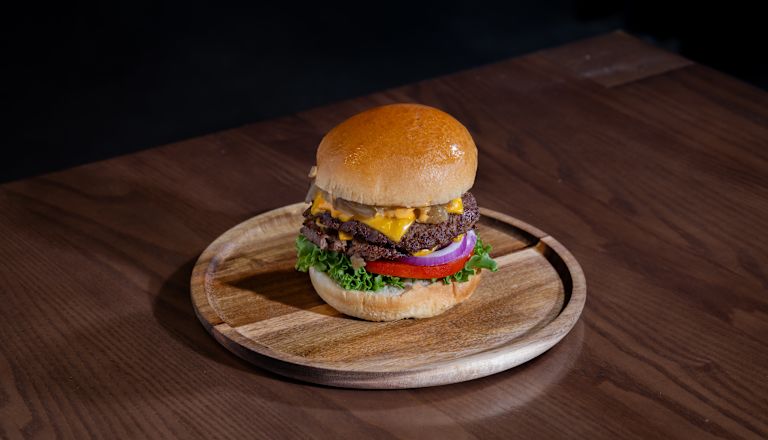 Burger pe o farfurie de lemn