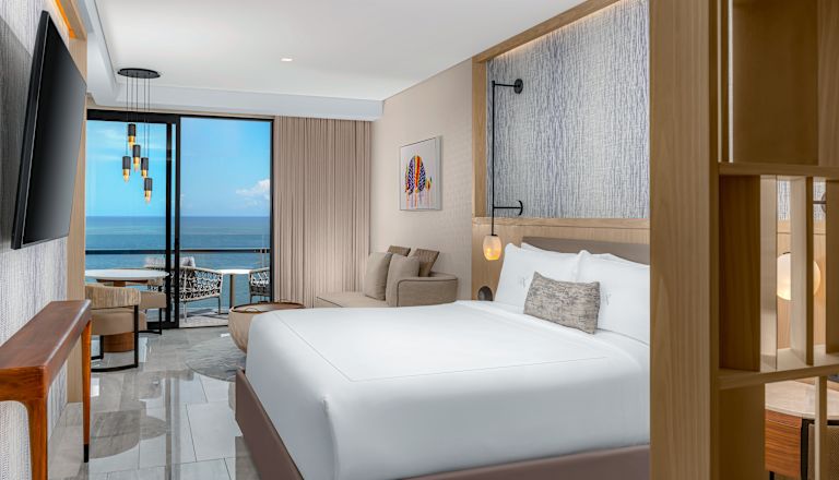 Deluxe ocean front king bedroom with wall mounted TV and sofa