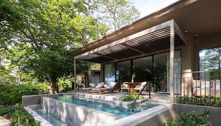 Patio privado de la suite Pacifico bajo los árboles, piscina profunda, divanes