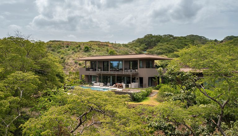 vista exterior de la suite Presidential con piscina privada al aire libre rodeada de árboles y colinas