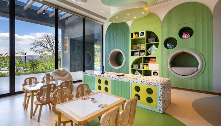 Club para niños con juegos y mesas con sillas