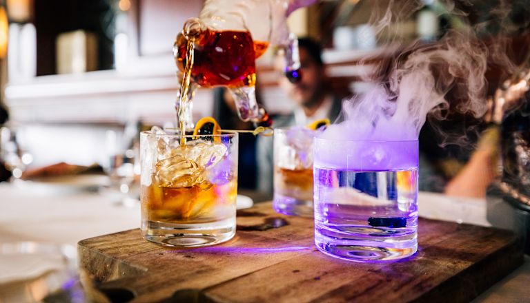 Restaurante Bull & Bear, barman que sirve una bebida con una jarra de toro