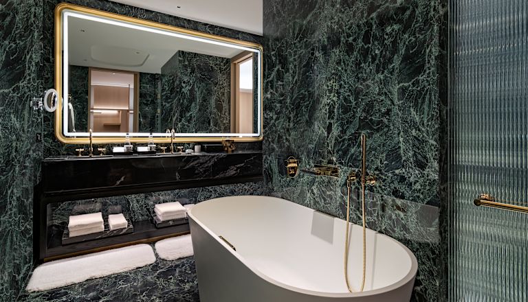 Bathroom with Tub and Dual Vanity Area with Lit Mirror