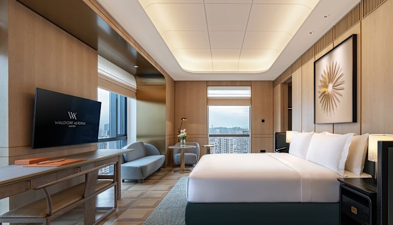Guest Room with Large Bed Sofa HDTV and City View